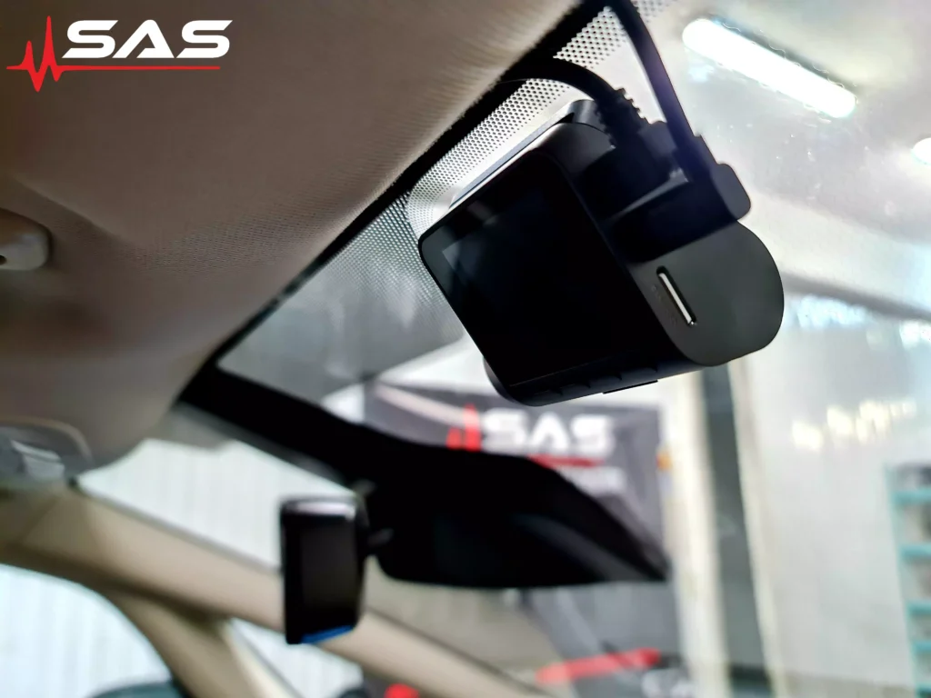 Kolejne ujęcie przedniego wideorejestratora z perspektywy wnętrza pojazdu. Urządzenie jest zainstalowane w sposób subtelny i schludny, z niewidocznymi przewodami. W tle logo Sound Audio System potwierdza autorytet wykonanej usługi.