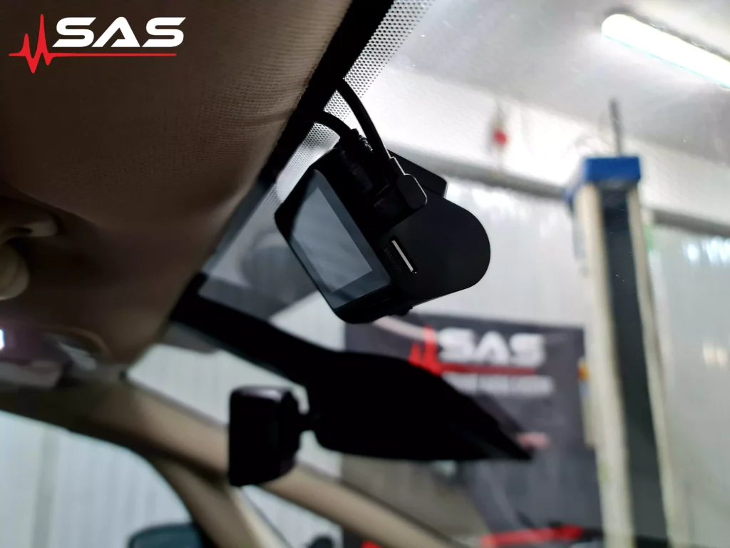 Inny kąt przedstawiający wideorejestrator w Fordzie S-Max. Instalacja została przeprowadzona z dbałością o detale, z uwzględnieniem komfortu kierowcy i pasażerów. Logo Sound Audio System na banerze w tle przypomina o profesjonalnym warsztacie, który wykonał usługę.