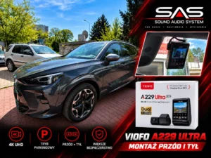 Samochód osobowy zaparkowany przed warsztatem z grafiką prezentującą zamontowany wideorejestrator VIOFO A229 Ultra.