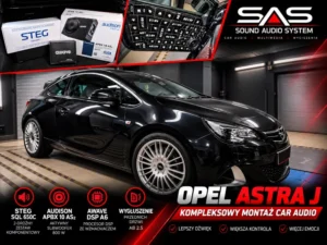 Czarny Opel Astra J w warsztacie z widocznymi komponentami audio i materiałami wygłuszającymi na grafice